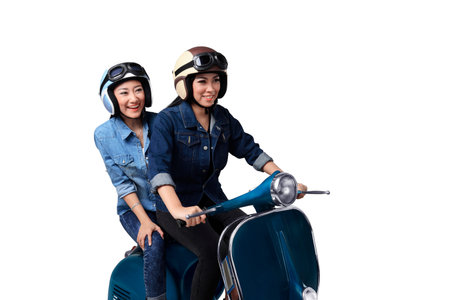 Two asian woman having fun when riding the scooter isolated over white background