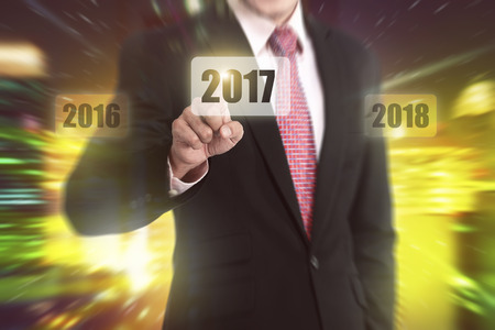 Businessman hand touching 2017 number on the virtual screenの写真素材
