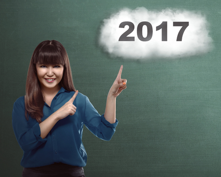Asian woman pointing finger to 2017 number. Happy new year conceptの写真素材