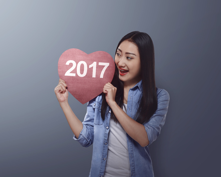 Asian woman holding red heart with 2017 number. Happy new year conceptの写真素材