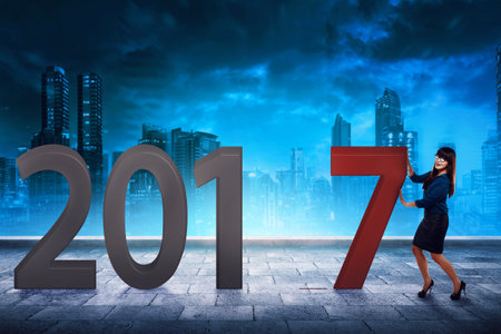 Beautiful asian business woman push number 7 to make 2017. Happy new year concept