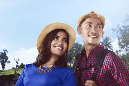 Portrait of happy young asian couple having fun on their hiking journeyの写真素材