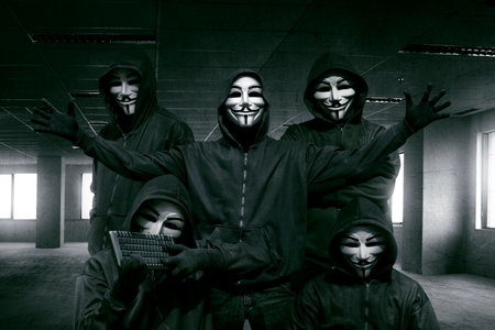 Group of hooded hacker with mask standing in the dark room backgroundのeditorial素材