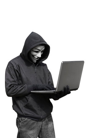 Hacker with anonymous mask with laptop while standing isolated against white backgroundのeditorial素材
