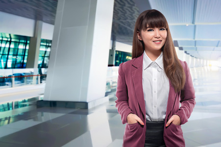 Beautiful asian business woman with hand on the pocket standing in the airportの写真素材
