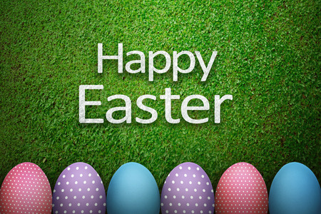Happy easter greeting with easter egg over green grass backgroundの写真素材