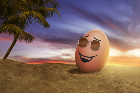 Happy easter eggs with sunglasses in the beach at sunsetの写真素材