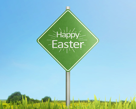 Happy easter greetings on traffic sign in the meadow fieldの写真素材