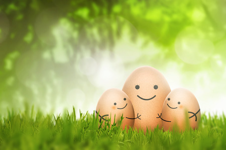 The big egg hugging small egg on the field over blurred backgroundの写真素材