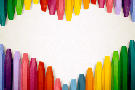 Row of colorful crayon over stripe pattern paper for copyspaceの写真素材