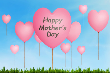 Happy Mothers Day message written on pink balloon with heart shape in the airの写真素材