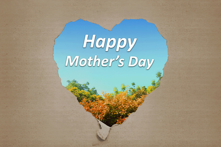 Happy Mothers Day greetings from ripped carton written against natural backgroundの写真素材
