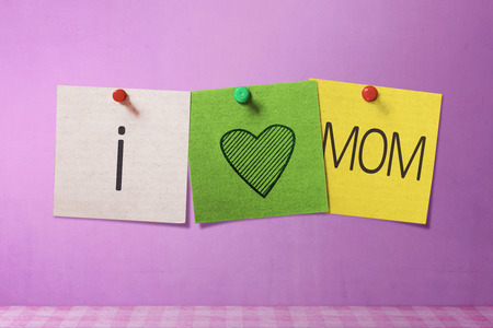 Happy Mothers Day message written on note paper in pink wall backgroundの写真素材