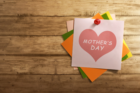 Mothers Day message written on stack of colorful paper note on wooden wallの写真素材