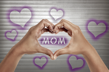 People hands in shape of heart with mom text on the metal doorの写真素材