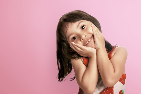 Young asian kid smiling with happy expression over pink backgroundの写真素材