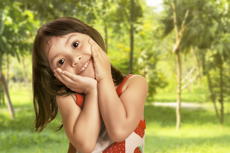 Little asian girl with is happy and excited face on spring parkの写真素材