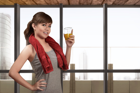 Young asian woman drinking a healthy natural juice for healthy with window glass backgroundの写真素材