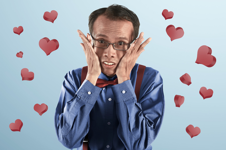 Young asian nerd man thinking with hand on face on blue backgroundの写真素材