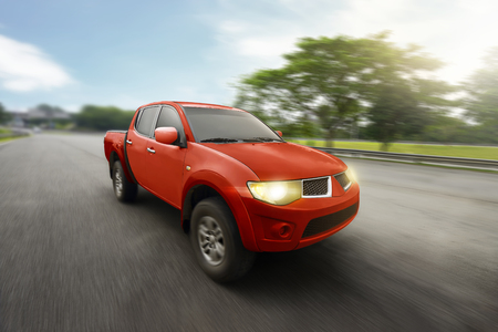Red four door pickup truck with high speed on highwayの写真素材