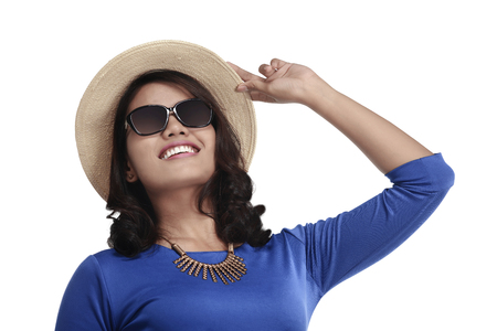 Happy asian woman with glasses and hat going vacation isolated over white backgroundの写真素材