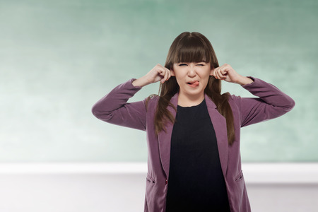 Cheerful asian woman with funny expression on the classroomの写真素材