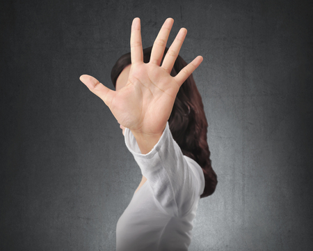 Portrait of asian woman showing stop with hand gesture with black wall backgroundの写真素材