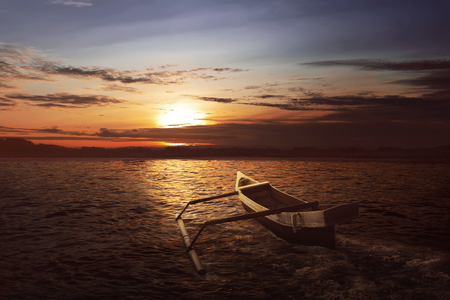 Wooden boat float with wave water at sunsetの写真素材