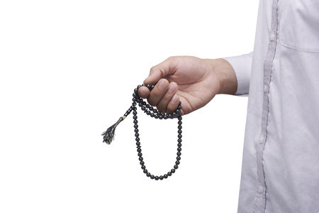 Hand of muslim man praying while holding tasbih isolated over white backgroundの写真素材