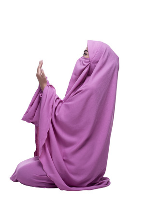 Side view of asian muslim woman wearing hijab praying isolated over white backgroundの写真素材