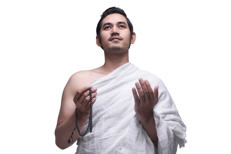 Religious asian muslim man in ihram dress ready for hajj isolated over white backgroundの写真素材