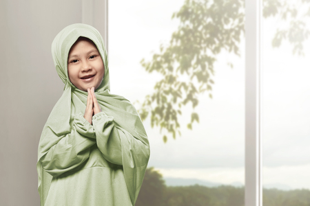 Asian muslim girl wearing hijab praying in the homeの写真素材