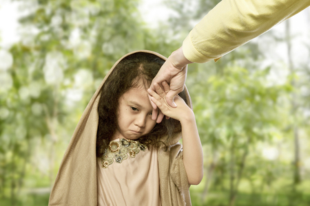 Asian muslim child kissing hand parents for traditional act of respect at outdoorの写真素材