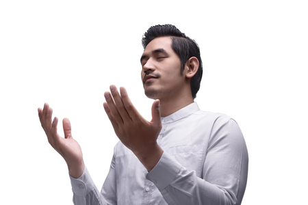 Religious asian muslim man praying to god isolated over white backgroundの写真素材
