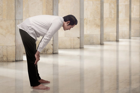 Religious asian muslim man in traditional dress praying in the mosqueの写真素材