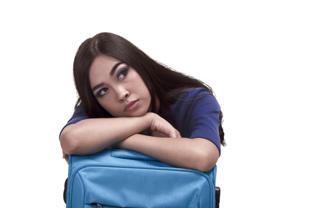 Beautiful asian woman traveler embrace a blue suitcase isolated over white backgroundの写真素材