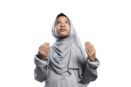 Little asian muslim girl praying to god isolated over white backgroundの写真素材