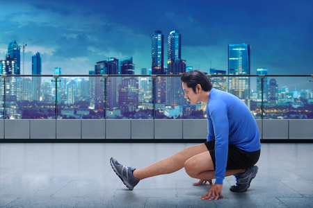 Portrait of asian man doing training before running workout at terrace gymの写真素材