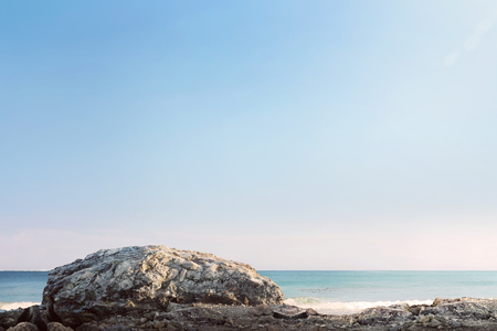 Giant rock and sea waves with blue sky at sunny dayの写真素材