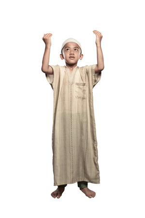 Portrait of asian muslim kid with cap praying isolated over white backgroundの写真素材