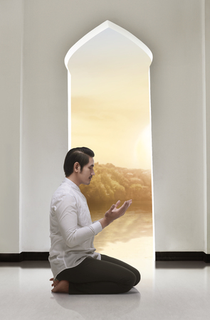 Religious asian muslim man kneeling and praying on the mosqueの写真素材