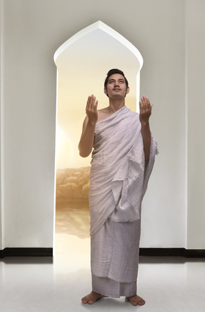 Handsome asian musim man wearing ihram and praying inside the mosqueの写真素材