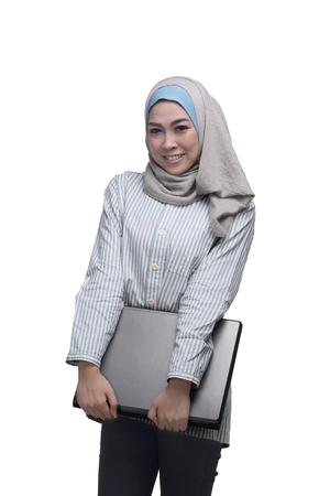 Beautiful asian muslim woman holding laptop isolated over white backgroundの写真素材