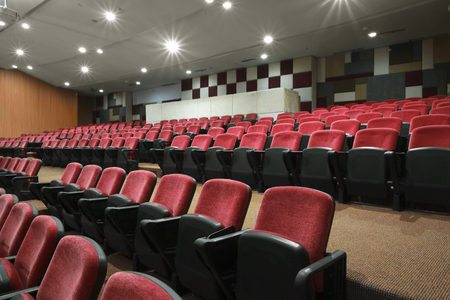 Bright white light with empty red seats in the movie theaterの写真素材