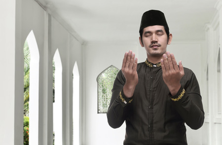 Religious asian muslim man praying to god inside the mosqueの写真素材