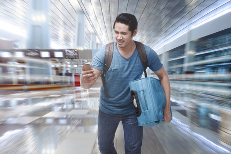 Young asian tourist rushing to boarding a plane on the departure areaの写真素材