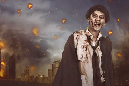 Portrait of horrible asian zombie man with suit on the ruin cityの写真素材