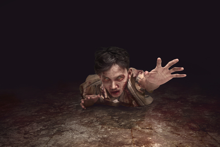 Scary asian zombie man crawling from the dark roomの写真素材