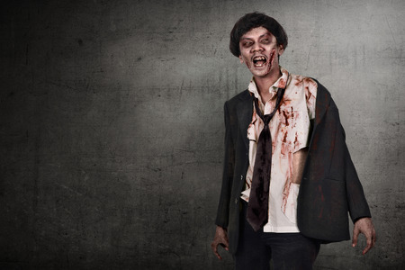 Portrait of asian zombies man with wounded face against dark wall backgroundの写真素材