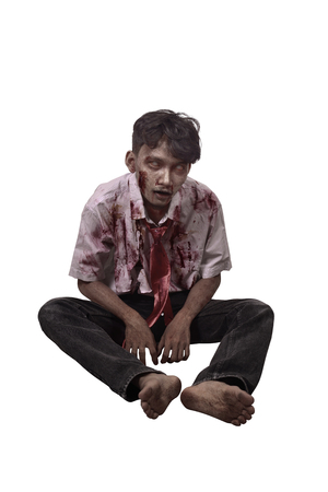 Spooky asian zombie man with blood sitting isolated over white backgroundの写真素材